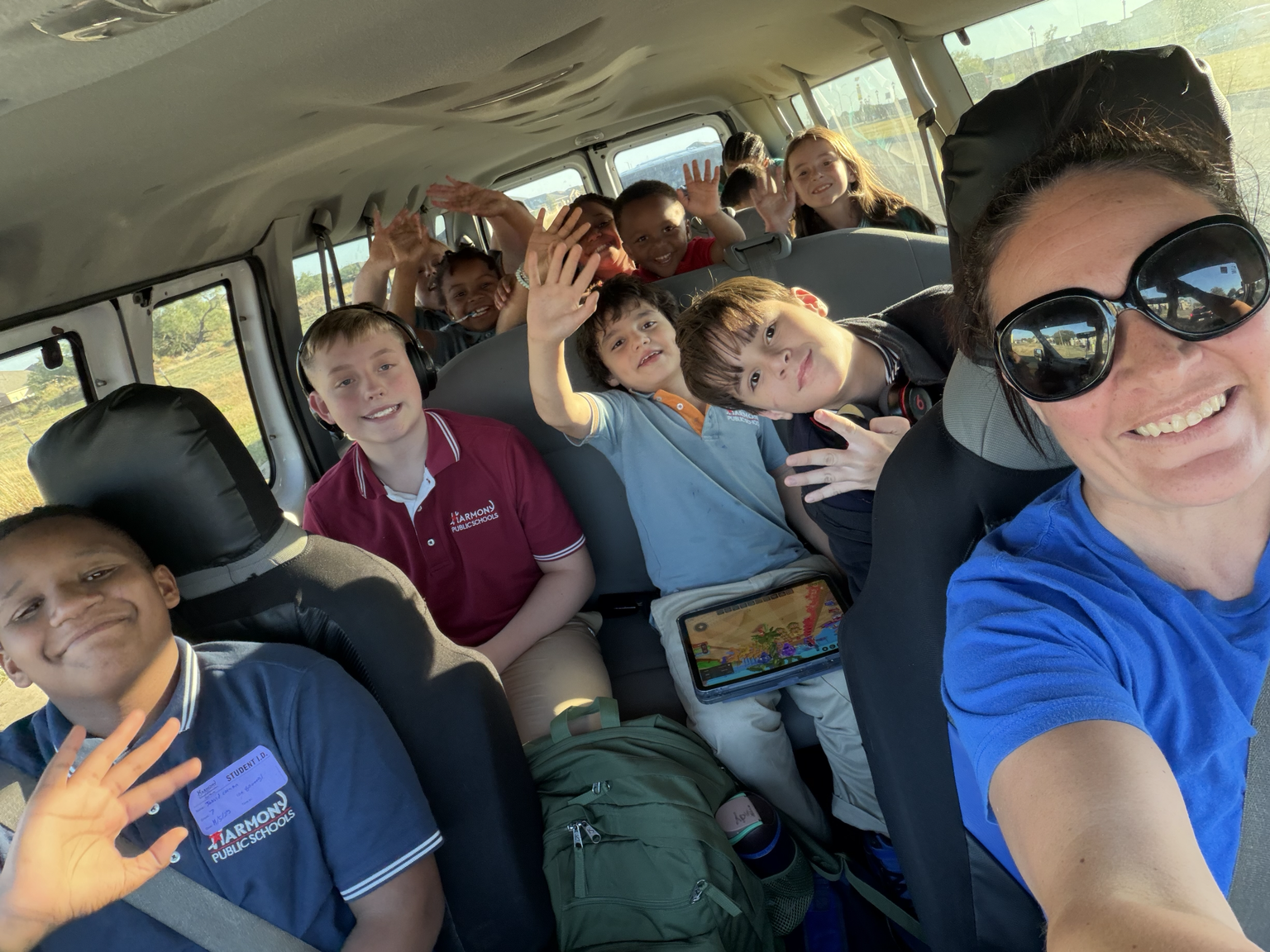Sensei Carrie with after-school students waving from the van during school pickup